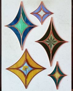 four different colored glass designs on a white wall