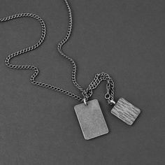 Our Duo Tags are forged in solid premium steel with an ages silver finish and imperfections. This men's custom pendant necklace is waterproof, tarnish proof and hypoallergenic. 68 character limit for each side of the large tag. If you prefer our standard "modern font" instead of the "typewriter font" as shown, please let us know in the "notes" section in your cart. The small tag cannot be engraved. We copy and paste exactly what you request for engraving. Please be mindful of your upper and lowe Engraved Stainless Steel Necklace With Square Pendant, Gunmetal Necklace With Silver Chain For Gift, Gunmetal Necklace With Silver Chain As A Gift, Engraved Stainless Steel Square Pendant Necklace, Sterling Silver Dog Tag Necklace With Adjustable Chain, Metal Pendant Necklaces For Father's Day, Engraved Gunmetal Necklace For Gift, Minimalist Gunmetal Necklace For Gift, Gunmetal Pendant Necklace For Gift