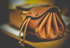 a brown purse sitting on top of a wooden table