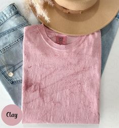 a pink shirt and jeans with a hat on top