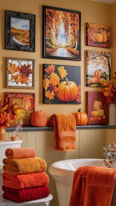 towels and pumpkins are displayed on the wall above a toilet in this fall bathroom