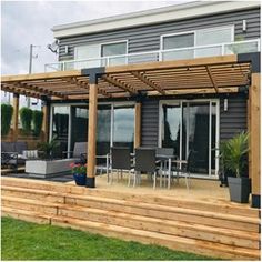 an outdoor patio with wooden steps leading up to the deck and seating area on top of it