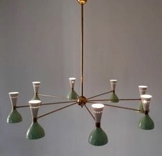 a green chandelier with six lights hanging from it's center and four arms