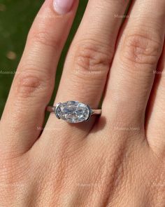 a woman's hand with a ring on it and a diamond in the middle