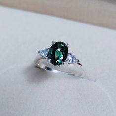 a green and white ring sitting on top of a table next to a piece of paper