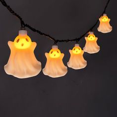 halloween ghost lights hanging from a string on a black background