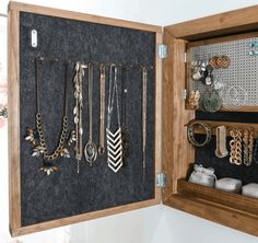 an open wooden jewelry box filled with lots of necklaces