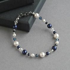 This navy and white bracelet is created using glass pearls, sparkling crystals and glass beads. The crystals really sparkle in the light and compliment the lustre of the pearls. Each dark blue pearl and crystal bracelet measures 18cm/7.25 inches in length and is finished with a gunmetal-plated lobster clasp. Adjustable Blue Pearl Bracelet For Wedding, Chunky Stone Necklace, Floating Pearl Necklace, Chunky Pearl Necklace, White Pearl Jewelry, Silver Bar Earrings, Fused Glass Necklace, Fused Glass Earrings, Jewelry King