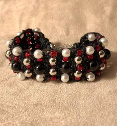 Bracelet of onyx beads, faux pearls, plastic silver beads and red seed beads, braided in black waxed cotton cord. Adjustable 8-10.5 inches. Black Beaded Braided Bracelet As Gift, Black Beaded Braided Bracelet, Handmade Adjustable Red Pearl Bracelet, Handmade Red Adjustable Pearl Bracelet, Adjustable Pearl Bracelet With Colorful Beads For Party, Adjustable Beaded Braided Bracelets For Party, Adjustable Black Pearl Bracelet, Red Beaded Pearl Bracelet With Round Beads, Handmade Black Braided Bracelets With Round Beads