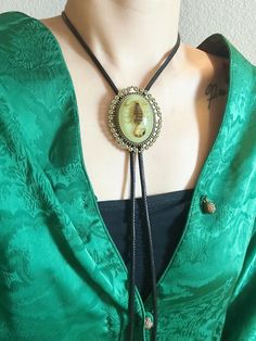 Introducing our striking Real Scorpion Bolo Tie--a captivating blend of gothic style and Western charm. This unique piece features a real scorpion delicately preserved within resin, set in an ornate antique-style frame that glows in the dark. The bolo tie is completed with intricately detailed tips, adding an extra touch of sophistication to the braided leather cord. Perfect for those who appreciate the fusion of nature and fashion, this bolo tie adds a touch of intrigue and fascination to any ensemble. Celebrate the extraordinary with this one-of-a-kind accessory that captures the essence of nature in a truly captivating way. Product Details: *Material: Real Scorpion, Resin, polyester cord, Metal *Real scorpion specimen preserved in resin *Ornate antique-style frame with glow in the dark Gothic Adjustable Necklace For Costumes, Vintage Adjustable Jewelry For Halloween, Vintage Adjustable Halloween Jewelry, Vintage Adjustable Necklace For Halloween, Vintage Black Bolo Ties As Gift, Vintage Black Bolo Ties For Gift, Handmade Adjustable Jewelry For Costume Party, Bolo Tie Women Outfit, Tie Women Outfit