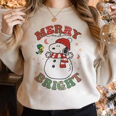 a woman wearing a merry sweater with a snowman on it