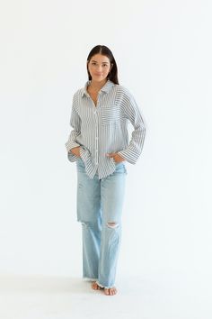 Stay cool and stylish this summer with our Zuma Button Down, featuring pretty iridescent buttons and a raw hem. This super lightweight top offers an effortless, relaxed, and roomy fit, making it perfect for warm weather. Best of all? Its 100% cotton! Wear it buttoned up for a polished look or unbuttoned over a swimsuit or tank for a breezy, casual vibe. This versatile piece is a must have summer staple! Malibu Collection FIT Relaxed Roomy Fit Iridescent Buttons High-Low Raw Hem Clancy is 5'9 Wea Relaxed Summer Tops With Frayed Hem, Chic Relaxed Fit Top With Frayed Hem, Chic Tops With Frayed Hem And Relaxed Fit, Spring Blouse With Button Cuffs And Relaxed Fit, Everyday Relaxed Collared Blouse, Relaxed Fit Blouse With Shirttail Hem For Vacation, Relaxed Shirt With Shirttail Hem For Day Out, Chic Tops With Frayed Hem, Versatile Button-up Vacation Tops