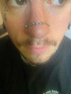 a man with piercings on his nose looking at the camera