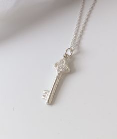 "This key pendant has been handmade using fine silver and features a trefoil shaped top set with a 2mm sparkly cubic zirconia. This pendant measures 9mm across at its widest point and is approx. 25mm in length. This pendant has been hallmarked by the London Assay Office. It is available on a 16, 18\" or 20\" sterling silver rope chain. Have a look at my necklace size guides in the product pictures to see how these sizes might fit you. Keys are one of the oldest lucky charm symbols. The giving of Silver Key Pendant Jewelry, Silver Pendant Necklace With Two Keys, Silver Key Pendant Necklace, Silver Key Necklace For Gift, Silver Necklace With Two Keys For Gift, 21st Key, Key Locket, Silver Key Necklace, Silver Key