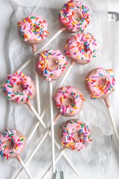 there are many donuts with sprinkles on the sticks in the box