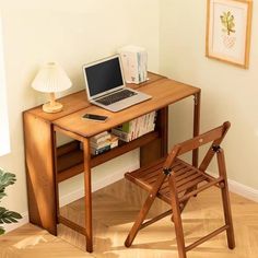 a laptop computer sitting on top of a wooden desk next to a chair and potted plant