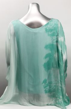 Imagine wearing this incredible top at an outdoor party or out to dinner with friends. A glorious flowy fabrication creates a stunning tunic in a mint tie dye pattern. Create a classy and fashion forward look with this tunic by pairing it with white bottoms or black slacks. Color- Mint tie dye. Knit lining solid mint color. Flowy fabrication on the outside. A knit tank lining on the inside prevents see through. Fabric- 70% Viscose. 30% Silk. Care-Hand wash, machine wash cold separately. Dry clea Green Silk V-neck Top, Green Flowy Blouse For Vacation, Spring Green Flowy Blouse, Long Sleeve Tie-dye Blouse For Summer, Summer Tie-dye Long Sleeve Blouse, Long Sleeve Tie Dye Blouse For Summer, Summer Tie Dye Long Sleeve Blouse, Summer Long Sleeve Tie Dye Blouse, Green Silk Blouse For Summer