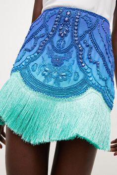 Borrowing From The Art Deco Era, This Opulently Beaded Ombre Mini Skirt Blends Swishy Tassels With A High-Rise Fit And Undeniably Glamorous Vibe. The Tassels Come Cut In A Draped, Asymmetric Line, Giving This High-Voltage Piece A Beautiful Sense Of Movement.Style: Skirtdesign: Embroideredfabric: Wovenlength: Mini Beaded Fringe Skirt, Fringe On Clothes, Beaded Mini Skirt, Beaded Skirt Outfit, Exotic Makeup Looks, Ss24 Resort, Fringe Skirt Outfit, Asymmetrical Skirts, Trendy Summer Tops