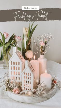 a white table topped with candles and vases filled with flowers next to each other