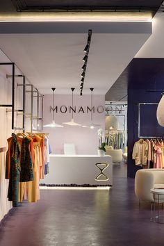 the interior of a clothing store with clothes on racks