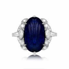 This superb Art Deco ring features a natural Burmese carved cabochon sapphire weighing approximately 8.64 carats. Accenting the center stone is an array of single-cut, marquise, and baguette-cut diamonds. This ring is antique and was handcrafted in the 1920s.
The total approximate diamond weight is 0.60 carats.
The measurements of the center sapphire are approximately 16.25mm x 9.25mm.
The current finger size of this ring is 6 and it can be resized.
Ready to Make It Yours? Contact us to reserve Luxury Dazzling Sapphire Ring With Diamond Accents, Luxury Dazzling Sapphire Diamond Ring, Luxury Heirloom Sapphire And Diamond Ring, Luxury Dazzling Gemstones With Accents, Luxury Diamond Topaz Ring In Art Deco Style, Luxury Antique Cabochon Sapphire Ring, Classic Cabochon Sapphire Ring For Formal Occasions, Classic Formal Cabochon Sapphire Ring, Classic Formal Sapphire Cabochon Ring