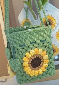 two crocheted bags with sunflowers on them sitting next to each other