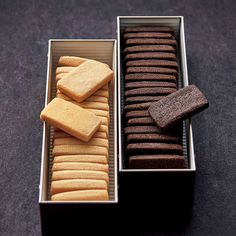 two tins filled with different types of cookies