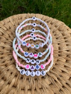 a stack of bracelets with the words mama babe spelled in white and pink beads