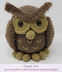 an owl stuffed animal sitting on top of a white surface with the words hygge owl written below it