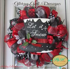 a red and black mesh wreath with a sign on it that says let it snow