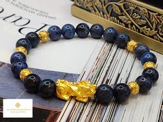 Gift yourself or your loveonce this beautiful bracelet. Crafted with 24 Karat Real Gold and Dumortierite. Metal: 24K Gold (Au999) Colour: Yellow Gold Gold Weight: Approximately 1.30gram Stone/Crystal Size: Approximately 8.3mm Metal is Made of Real 24K Gold. Never Gold Filled. Never Gold Plated.  🧧Pixiu is a powerful Feng Shui symbol of wealth. It is believed that wearing the symbol of Pixiu brings money and good fortune to its wearer. This mythical creature is also thought to protect people fro Spiritual Gold Bracelet With Round Beads As Gift, Money Ball, Feng Shui Bracelet, Pixiu Bracelet, Feng Shui Symbols, Gold Money, Spiritual Protection, Mythical Creature, Protection Bracelet