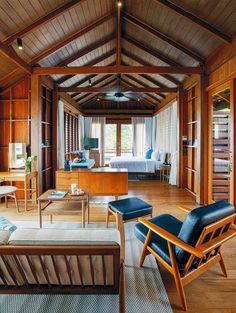 a living room filled with furniture and wooden walls