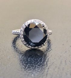 DeKara Designs Collection Metal- 95% Platinum, 5% Iridium. Stones- Genuine Round Black Diamond 6.50 Carats 10.25 MM, 44 Round Diamonds F-G Color VS1-VS2 Clarity 0.28 Carats. Size- 5 3/4. FREE SIZING Beautiful Handmade Platinum Halo Black Diamond Engagement Ring. The beautiful and fiery round black diamond is uniquely cut and is professionally set in between four Eagle Claw prongs. The center black diamond is surrounded by 24 round dazzling diamonds that are meticulously French Pave set, as well Formal Gia Certified Round Stone Ring, Formal Gia Certified Rings, Gia Certified Round Cut Halo Ring For Formal Occasions, Classic Black Diamond Ring With Round Band, Luxury Halo Ring With Round Stone For Formal Occasions, Classic Black Diamond Ring For Wedding, Black Diamond Ring With Halo Setting For Formal Events, Black Diamond Ring With Halo Setting For Formal Occasions, Sapphire Halo Ring With Vvs Clarity