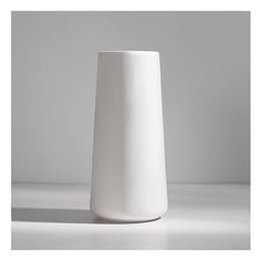 a white vase sitting on top of a table