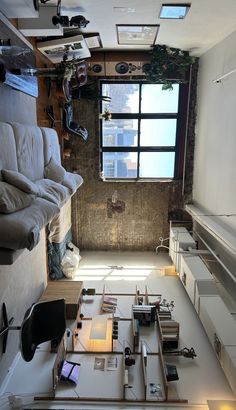 a living room filled with lots of furniture next to a large window on the wall