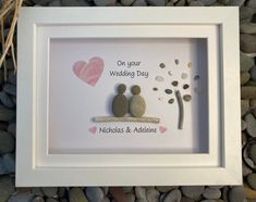 two pebbles are sitting on a bench next to a tree and heart - shaped rocks