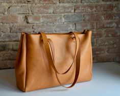 Meet our new bag! The Toronto bag is a bag made of an exclusive Full Grain Vegetable Tanned cow Leather, with top zipper and inside leather pocket, in a beautiful camel shade. Long handles to wear the bag on your shoulders (10.5-11 inch drop - 27-28 cm) This bag has a clasp in both top edges of the bag that gives this beautiful structure and design, and if necessary you can open it and it increases the size of the bag.  MEDIUM 13.4 inches wide  (34 cm width) 10 in high (25 cm) 3.5 -4 inches deep Brown Weekender Bag For Everyday Use, Cognac Satchel Bag For Everyday Use, Brown Tote Weekender Bag For Everyday Use, Cognac Weekender Bag For Daily Use, Brown Weekender Bag With Adjustable Strap For Everyday Use, Light Brown Tote Shoulder Bag For Everyday, Cognac Large Capacity Weekender Bag, Everyday Cognac Satchel Bag, Cognac Satchel Weekender Bag For Everyday