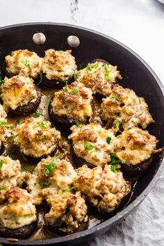 stuffed mushrooms in a skillet with cheese and parsley on top, ready to be eaten