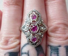 **IMPORTANT!! This ring is made to order! It has a 1-2 week delivery time!! I will ship it asap This is a gorgeous Ring, perfect as a treat for yourself, or a gift from your partner! *wink *wink!♥ A lovely detailed filigree design holds 3 natural rubies in prong settings, and 10 tiny seed pearls in two different sizes! The quality of this piece is impeccable, and the detail is amazing! Light comes through the back side of the rubies to show of their clarity and dark pink color! Cast from an auth Handmade Art Deco Jewelry For Anniversary, Art Deco Ruby Ring Jewelry, Art Deco Ruby Jewelry As A Gift, Art Deco Ruby Ring Gift, Art Deco Ruby Jewelry Gift, Art Deco Ring With Accent Stones For Gifts, Art Deco Ring With Accent Stones Gift, Art Deco Rings With Accent Stones For Gifts, Art Deco Hallmarked Ruby Ring For Gift