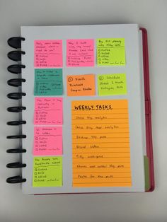 a notebook with sticky notes attached to the pages and pen on top of it that says weekly tasks