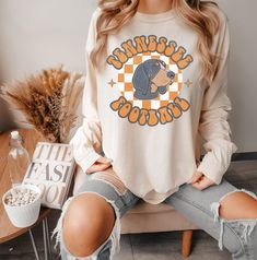 Show your Tennessee Vols spirit with our cozy long sleeve Comfort Colors shirt! Perfect for game day, this orange and white football tee proudly represents the Volunteer State's football excitement. Get ready to cheer on your team in style during Football Time In TN! 📌IMPORTANT: This is a regular fit Long Sleeve T-shirt, if you want an oversized look, please size up. ⭐️For the T-shirt dress look, size up at least 2 sizes. Please refer to size chart for specific shirt measurements.⭐️ 📌Our desig Long Sleeve School Spirit T-shirt For Fall, School Spirit Long Sleeve T-shirt For Fall, Long Sleeve T-shirt For School Spirit In Fall, Pre-shrunk Orange Long Sleeve Tops, Orange Long Sleeve Top For College, Long Sleeve Orange Tops For College, Orange Pre-shrunk Long Sleeve T-shirt, Tn Vols Football, Vols Football