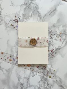 a card with a button on it sitting on a marble surface