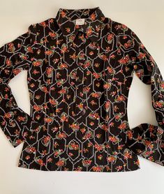 "1960'S MOD Blouse in a novelty print of flower baskets. This is 100% combed cotton. There are huge butterfly lapels that are 4-1/2 inches long. This top is nipped at the waist and flares a bit at the hip. This is in EXCELLENT VINTAGE CONDITION. This garment has never been worn, and is considered NOS - New-Old Vintage Dead-Stock. The LABEL READS: \"TGL\" Stockholm European size 40 (the great britain & usa sizes are not listed correctly) DROP DRY ( lol.. which I think they meant DRIP DRY ) Je Collared Floral Print Patterned Tops, Vintage Patterned Collared Top, Vintage Collared Blouse With Graphic Print, Vintage Patterned Top With Graphic Print, Retro Patterned Top With Floral Print, Retro Patterned Tops With Floral Print, Fitted Vintage Blouse With Vintage Pattern, Retro Patterned Tops For Spring, Retro Floral Print Patterned Top