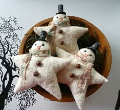 three snowmen in hats and scarfs are placed on top of two white stars