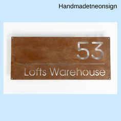 a wooden sign that says lofts warehouse with the number 53 on it's side