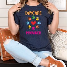 a woman sitting on a couch wearing a t - shirt with the words day care and hand prints