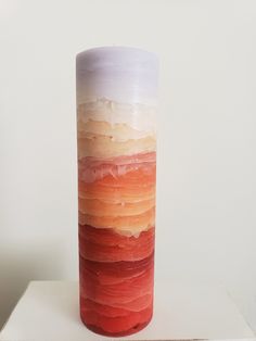 a tall glass vase sitting on top of a white table