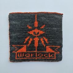 a knitted patch with an orange and black design