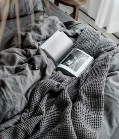 an open book sitting on top of a bed