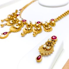 Make a statement with our Vibrant Antique Hanging Flower Necklace Set, crafted with 22k gold weighing 68.8 grams and featuring stunning Kundan stones. This antique finished necklace boasts a set length of 16.5" with 0.8" adjustable links and a secure hook lock. The striking hanging flower pendant has a drop length of 2", adding a touch of glamour to any ensemble. The set also includes matching earrings, 1.5" in length with screw backs. Elevate your style with this eye-catching piece, finished wi Festive 22k Gold Dual-tone Necklaces, Dual-tone 22k Gold Necklace For Weddings, Wedding Dual-tone 22k Gold Necklace, Heavy 22k Gold Necklace For Diwali, 22k Gold Hallmarked Necklace For Diwali, Traditional Dual-tone Necklace For Formal Occasions, Hallmarked 22k Gold Necklace For Diwali, Yellow Gold Kundan Necklace Hallmarked, Elegant Dual-tone Kundan Necklace For Ceremonial Occasion